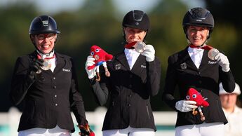 Die Bronzemedaillengewinnerinnen Heidemarie Dresing, Regine Mispelkamp und Anna-Lena Niehues vom Team Deutschland posieren für ein Foto auf dem Podium während der Medaillenvergabe im Mannschaftsreiten am neunten Tag der Paralympischen Sommerspiele Paris 2024 im Chateau de Versailles