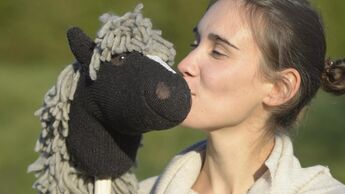 Frau küsst Hobbyhorse-Steckenpferd 