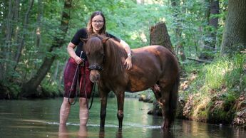 Helene Bockhorst mit ihrer Isländerstute in einem Bach